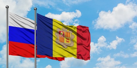 Russia and Andorra flag waving in the wind against white cloudy blue sky together. Diplomacy...