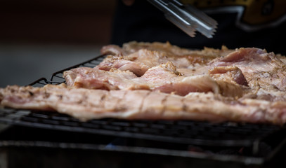 Roast pork on a charcoal flame.