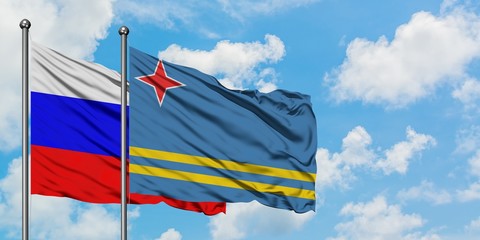 Russia and Aruba flag waving in the wind against white cloudy blue sky together. Diplomacy concept,...