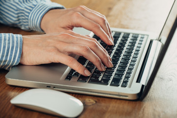 Woman working at home office hand on keyboard close up