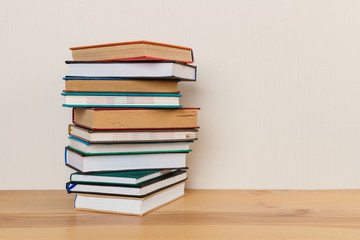 Simple composition of many hardback books, raw of books on wooden table and light  background