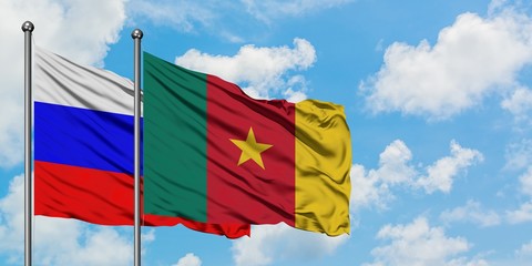 Russia and Cameroon flag waving in the wind against white cloudy blue sky together. Diplomacy concept, international relations.