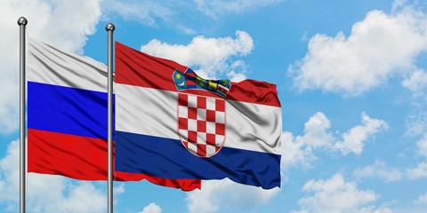 Russia and Croatia flag waving in the wind against white cloudy blue sky together. Diplomacy concept, international relations.