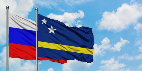 Russia and Curacao flag waving in the wind against white cloudy blue sky together. Diplomacy concept, international relations.