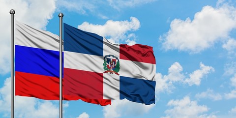 Russia and Dominican Republic flag waving in the wind against white cloudy blue sky together. Diplomacy concept, international relations.