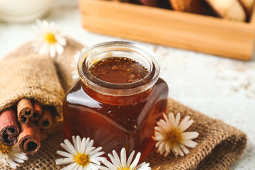 Jar with tasty honey on table