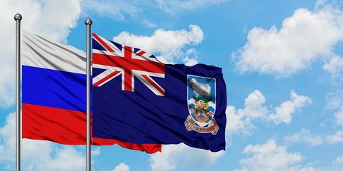 Russia and Falkland Islands flag waving in the wind against white cloudy blue sky together....