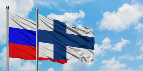 Russia and Finland flag waving in the wind against white cloudy blue sky together. Diplomacy concept, international relations.