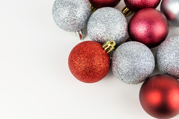 Silver and Red Christmas Tree baubles set against a stark white background.