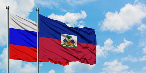 Russia and Haiti flag waving in the wind against white cloudy blue sky together. Diplomacy concept, international relations.