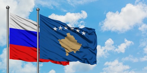 Russia and Kosovo flag waving in the wind against white cloudy blue sky together. Diplomacy concept, international relations.