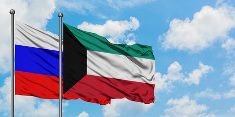 Russia and Kuwait flag waving in the wind against white cloudy blue sky together. Diplomacy...