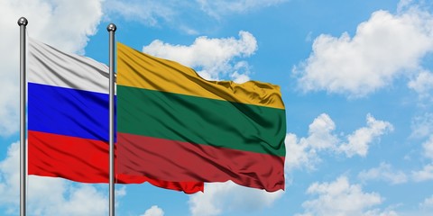 Russia and Lithuania flag waving in the wind against white cloudy blue sky together. Diplomacy concept, international relations.
