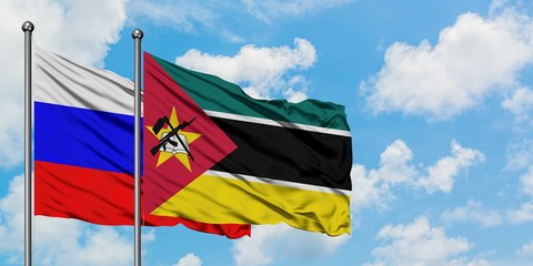 Russia and Mozambique flag waving in the wind against white cloudy blue sky together. Diplomacy...