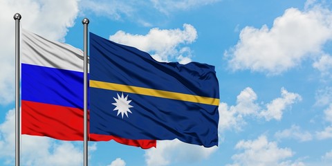 Russia and Nauru flag waving in the wind against white cloudy blue sky together. Diplomacy concept, international relations.