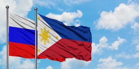 Russia and Philippines flag waving in the wind against white cloudy blue sky together. Diplomacy concept, international relations.