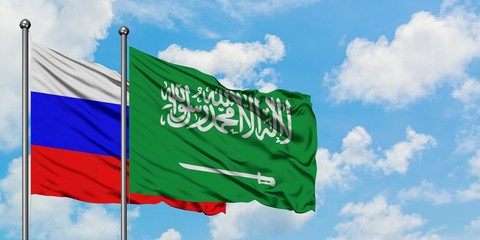 Russia and Saudi Arabia flag waving in the wind against white cloudy blue sky together. Diplomacy concept, international relations.