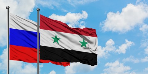 Russia and Syria flag waving in the wind against white cloudy blue sky together. Diplomacy concept, international relations.