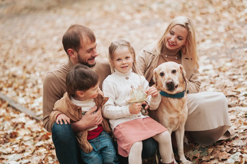 Happy family: mother, father, children son, daughter and dog labrador walking and have fun in park. Warm memories. Relations Love Generation lifestyle concepts. Family traditions
