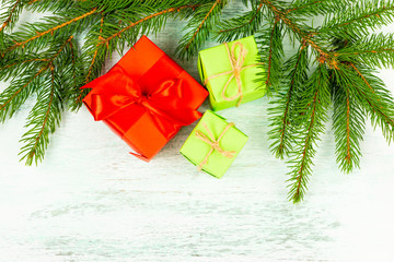Christmas composition. Three gift wrapping, branches of spruce, on a light wooden background. Christmas, winter, new year concept. Flat lay, top view, copy space