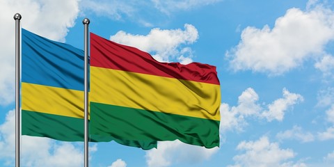 Rwanda and Bolivia flag waving in the wind against white cloudy blue sky together. Diplomacy concept, international relations.