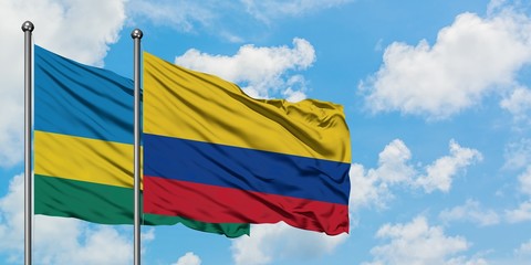 Rwanda and Colombia flag waving in the wind against white cloudy blue sky together. Diplomacy concept, international relations.