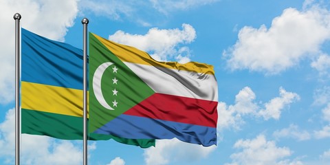 Rwanda and Comoros flag waving in the wind against white cloudy blue sky together. Diplomacy concept, international relations.