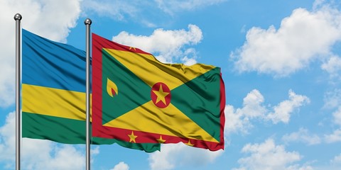 Rwanda and Grenada flag waving in the wind against white cloudy blue sky together. Diplomacy concept, international relations.