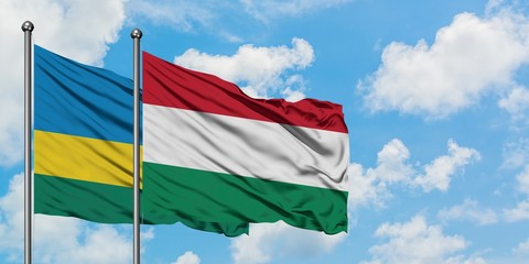 Rwanda and Hungary flag waving in the wind against white cloudy blue sky together. Diplomacy concept, international relations.