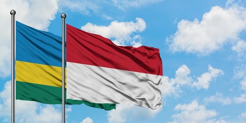 Rwanda and Indonesia flag waving in the wind against white cloudy blue sky together. Diplomacy concept, international relations.