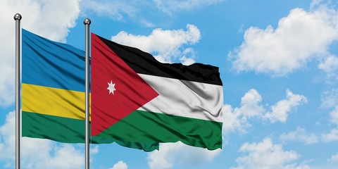 Rwanda and Jordan flag waving in the wind against white cloudy blue sky together. Diplomacy concept, international relations.