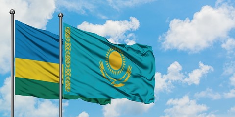 Rwanda and Kazakhstan flag waving in the wind against white cloudy blue sky together. Diplomacy concept, international relations.