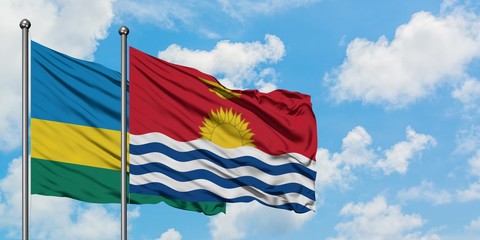 Rwanda and Kiribati flag waving in the wind against white cloudy blue sky together. Diplomacy concept, international relations.