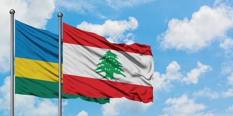 Rwanda and Lebanon flag waving in the wind against white cloudy blue sky together. Diplomacy...