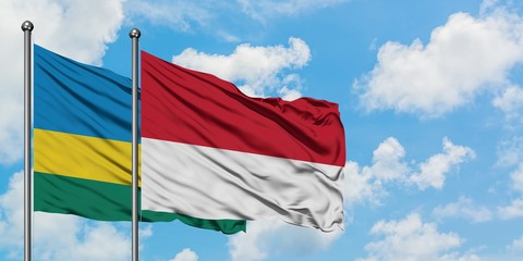 Rwanda and Monaco flag waving in the wind against white cloudy blue sky together. Diplomacy concept, international relations.