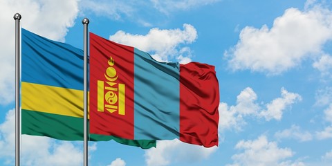 Rwanda and Mongolia flag waving in the wind against white cloudy blue sky together. Diplomacy concept, international relations.