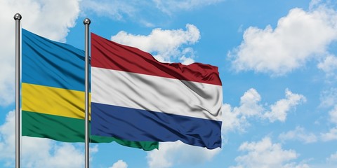 Rwanda and Netherlands flag waving in the wind against white cloudy blue sky together. Diplomacy concept, international relations.