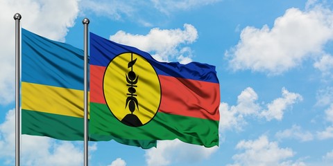 Rwanda and New Caledonia flag waving in the wind against white cloudy blue sky together. Diplomacy concept, international relations.