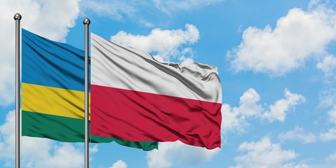 Rwanda and Poland flag waving in the wind against white cloudy blue sky together. Diplomacy concept, international relations.