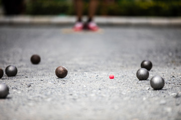 Petanque ball boules and small red jack on petanque field, Man playing petanque