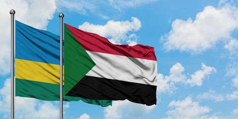 Rwanda and Sudan flag waving in the wind against white cloudy blue sky together. Diplomacy concept, international relations.