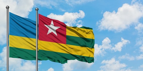 Rwanda and Togo flag waving in the wind against white cloudy blue sky together. Diplomacy concept, international relations.