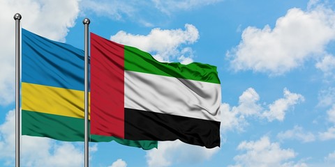 Rwanda and United Arab Emirates flag waving in the wind against white cloudy blue sky together. Diplomacy concept, international relations.