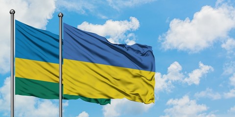 Rwanda and Ukraine flag waving in the wind against white cloudy blue sky together. Diplomacy concept, international relations.