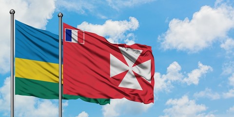 Rwanda and Wallis And Futuna flag waving in the wind against white cloudy blue sky together. Diplomacy concept, international relations.