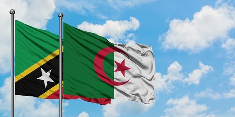Saint Kitts And Nevis and Algeria flag waving in the wind against white cloudy blue sky together....