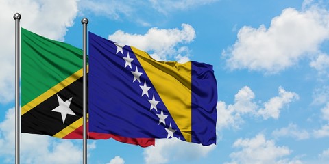 Saint Kitts And Nevis and Bosnia Herzegovina flag waving in the wind against white cloudy blue sky together. Diplomacy concept, international relations.