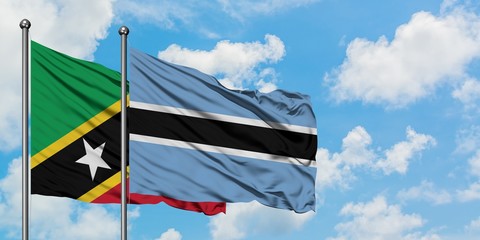 Saint Kitts And Nevis and Botswana flag waving in the wind against white cloudy blue sky together. Diplomacy concept, international relations.