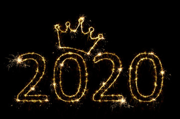 Holiday concept. Number 2020 with crown decor written sparkling sparklers isolated on black background. Overlay templatefor for christmas, new year, chinese new year greeting card