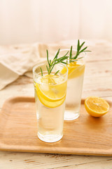 Glasses of cold lemonade on white table